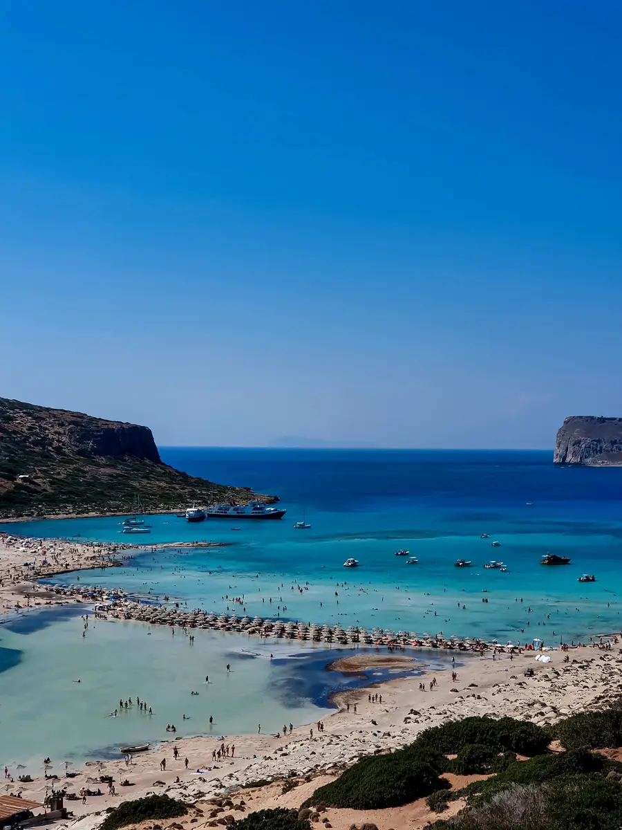 A beach with mountains behind the sea